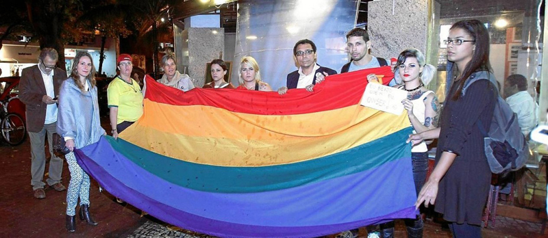 Orgulho e preconceito. Ativistas pelos direitos de minorias sexuais estendem bandeira em frente ao bar - Guilherme Leporace